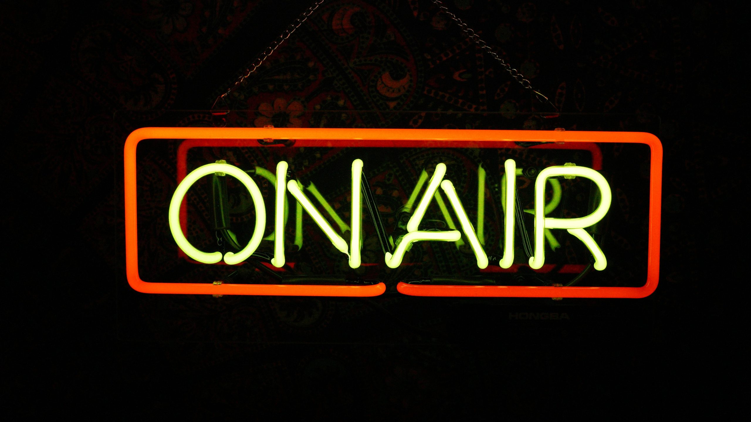 Leuchtschild über einer Tür zu einem Aufnahmestudio beim Film oder Radio mit dem Schriftzug "On Air", der leuchtet